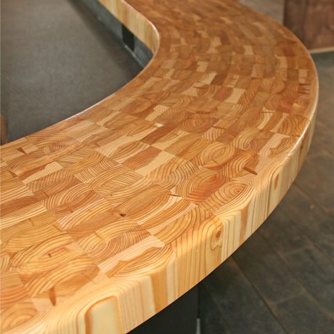 An inviting curved larch wood bar top custom designed for a commercial customer.